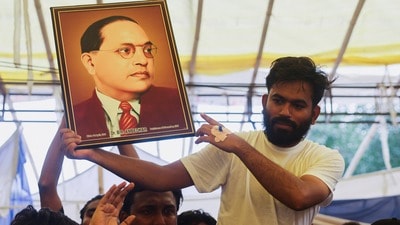విద్యాశాఖ మంత్రి ధర్మేంద్ర ప్రదాన్ రాజీనామా అనంతరం బాబాసాహెబ్ అంబేడ్కర్ చిత్రపటాన్ని చూపుతున్న సీజేపీ నేత అభిజీత్ దిప్కే (REUTERS)