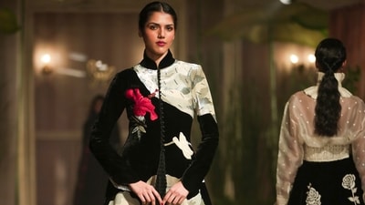 A black coat with a large red-and-gold floral appliqué on one shoulder was one of the stunning silhouettes seen on the ramp. (PTI) A black coat with a large red-and-gold floral appliqué on one shoulder was one of the stunning silhouettes seen on the ramp. (PTI)