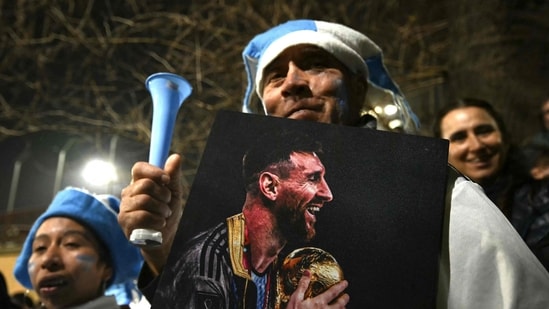 A fan holding a portrait of Argentina's forward Lionel Messi.