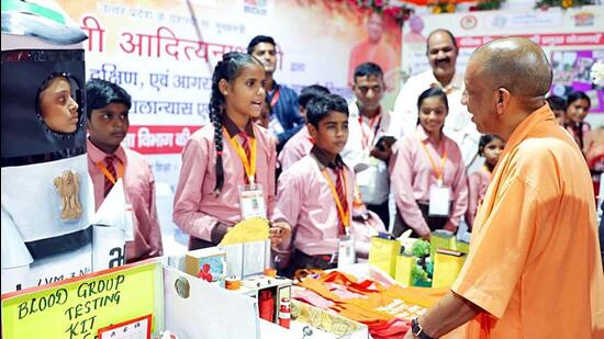 Chief minister Yogi Adityanath interacting with students during a public event in Agra on Saturday. (ANI PHOTO)