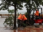 Workers clear fallen debris and obstacles from the road after Typhoon Noul, in Hong Kong, China, July 26, 2026.