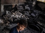 A young Palestinian boy walks in front of a mosque allegedly burned by Israeli settlers in the village of Qusra, south of Nablus in the Israeli-occupied West Bank on July 26, 2026.