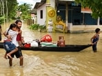 People shift their belongings to a safer place on a boat after floods and heavy rain, in Sivasagar, Assam.