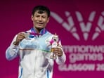 Silver medallist India's Rishikanta Singh poses for photographs during the presentation ceremony after the men's 60kg weightlifting competition