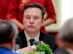 FILE PHOTO: Tesla CEO Elon Musk holds a mobile phone as he arrives to attend a state banquet with U.S. President Donald Trump and Chinese President Xi Jinping at the Great Hall of the People in Beijing, China, May 14, 2026. REUTERS/Evan Vucci/File Photo