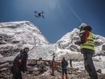An operator uses a heavy-lift drone to clear trash from the Everest base camp.