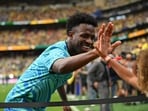 Vinicius Junior high fives a fan during the warm up before the match.