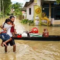 People shift their belongings to a safer place on a boat after floods and heavy rain, in Sivasagar, Assam.