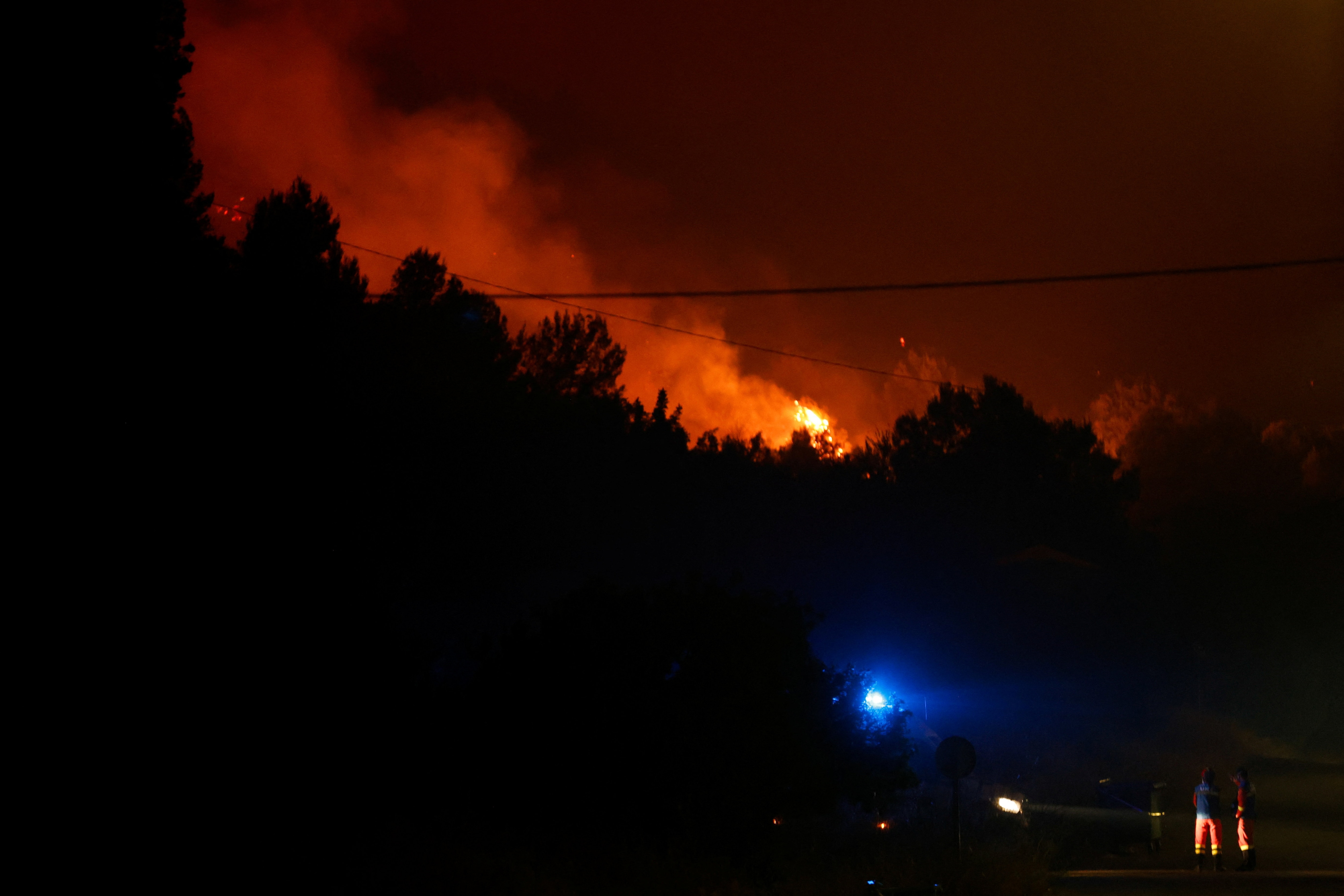 Emergency services members work during a wildfire in La Vall d'Uixo, Castellon, Spain. (File Photo/Reuters)