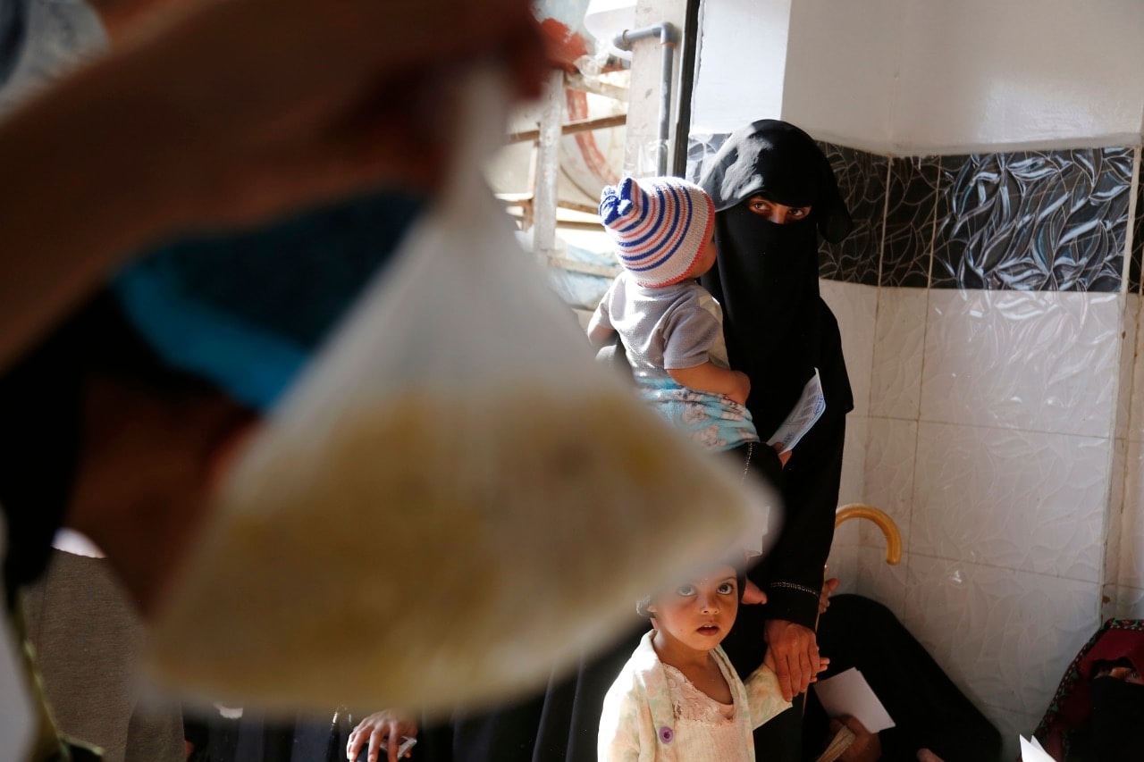 A family waiting to receive food in Yemen in 2022.