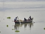Fishermen try to catch fish from the Ganga river as the water level rises in Prayagraj on Monday (PTI)