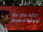 FILE PHOTO: A woman walks past a signboard of Bank of Baroda outside their branch office in New Delhi, India, June 20, 2023. REUTERS/Anushree Fadnavis/File Photo