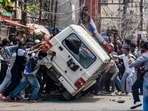 Protesters topple a police vehicle during the 'Bihar Bandh' called over the alleged NEET paper leak and police action against protesting students, in Patna on Saturday, July 25.