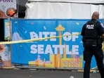 SEATTLE, WASHINGTON - JULY 26: A police officer walks by a sign for the Bite of Seattle food festival on July 26, 2026 in Seattle, Washington (Photo by David Ryder / GETTY IMAGES NORTH AMERICA / Getty Images via AFP)