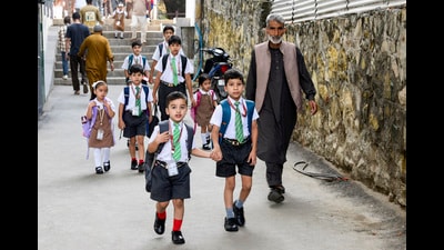 Students walk towards their school on the first day of classes after a 21-day summer break in Srinagar on Monday. (ANI)
