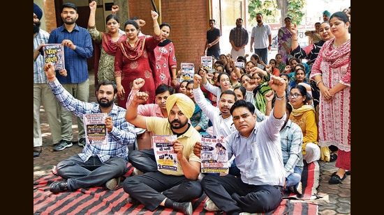 Employees of Aam Aadmi Clinics raising slogans during a protest outside the civil surgeon office in Amritsar on Monday. (Sameer Sehgal/HT)