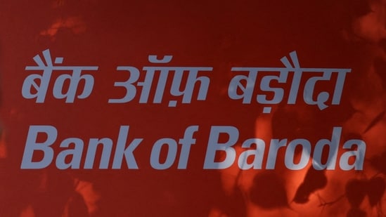FILE PHOTO: A woman walks past a signboard of Bank of Baroda outside their branch office in New Delhi, India, June 20, 2023. REUTERS/Anushree Fadnavis/File Photo