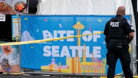 SEATTLE, WASHINGTON - JULY 26: A police officer walks by a sign for the Bite of Seattle food festival on July 26, 2026 in Seattle, Washington (Photo by David Ryder / GETTY IMAGES NORTH AMERICA / Getty Images via AFP)
