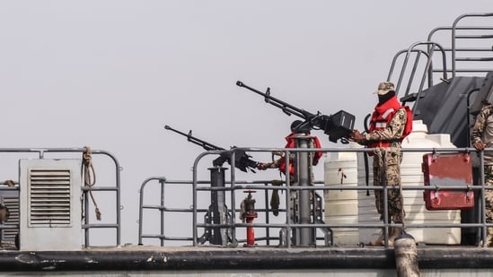 Sailors from the navy of Yemen's Aden-based internationally recognised government stand at machine-gun positions aboard a vessel patrolling a shipping lane off Hanish Island in the Red Sea on July 27, 2026.