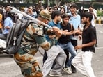 A security official carries out Lathi charge on protestors during their protest march towards Parliament called by Cockroach Janta Party.