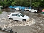 Vehicles wade through the waterlogged stretch at NH-48 service road near sector 15 , in Gurugram.