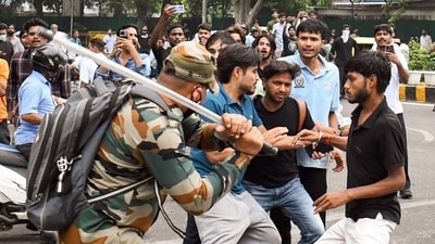 A security official carries out Lathi charge on protestors during their protest march towards Parliament called by Cockroach Janta Party. (ANI) A security official carries out Lathi charge on protestors during their protest march towards Parliament called by Cockroach Janta Party. (ANI)
