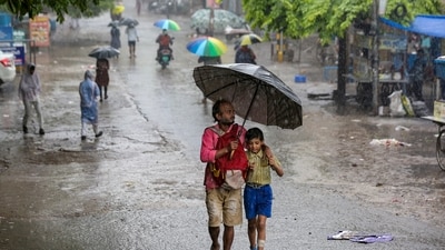 A man with a child makes his way amid heavy monsoon rain, in New Delhi, Tuesday, July 28, 2026. Parts of Delhi received rain with the India Meteorological Department (IMD) issuing an 'orange' alert for more rain at several places over the next few hours. (PTI)