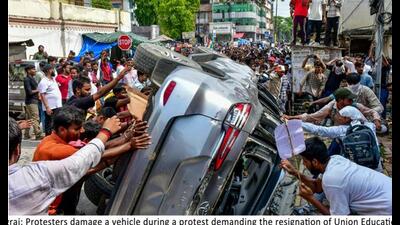 Protesters vandalising a vehicle during a protest over alleged irregularities in the NEET examination, in Prayagraj, on July 25. (PTI Photo)