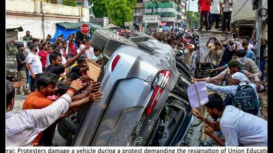 Protesters vandalising a vehicle during a protest over alleged irregularities in the NEET examination, in Prayagraj, on July 25. (PTI Photo)