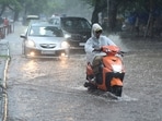 Commuters on their way during rain and waterlogging at Aroma Light Point in Chandigarh on Tuesday. (Keshav Singh/HT)