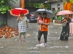 People wade through a waterlogged road in Mayur Vihar Phase 2 on Tuesday.