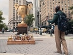 People take pictures of the 'Iran War Participation Trophy' at Foley Square on July 29, 2026 in New York City.