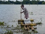 A man paddles a makeshift bamboo raft through floodwaters, in Sivasagar district, Assam.