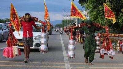 Kanwariyas return home after collecting holy Ganga water on NH-58 in Haridwar on Thursday. (HT photo | Rameshwar Gaur)