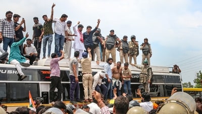 Farmers climb atop a bus as they stage a protest to press for various demands, including 100 per cent moong procurement at MSP, in Bhopal, Madhya Pradesh, Wednesday. (PTI Photo) Farmers climb atop a bus as they stage a protest to press for various demands, including 100 per cent moong procurement at MSP, in Bhopal, Madhya Pradesh, Wednesday. (PTI Photo)
