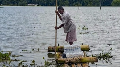 A man paddles a makeshift bamboo raft through floodwaters, in Sivasagar district, Assam. A man paddles a makeshift bamboo raft through floodwaters, in Sivasagar district, Assam.