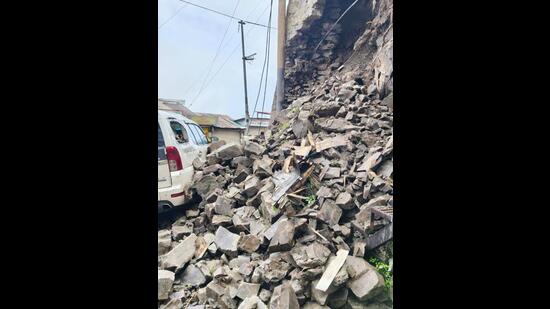 A parked vehicle damaged after the retaining wall collapse at Shimla’s Dhalli on Wednesday. (Deepak Sansta/HT)