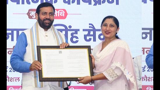 Chief minister Nayab Singh Saini handing over job letter to a recruit during an event programme at Tau Devi Lal Stadium in Panchkula on Wednesday.