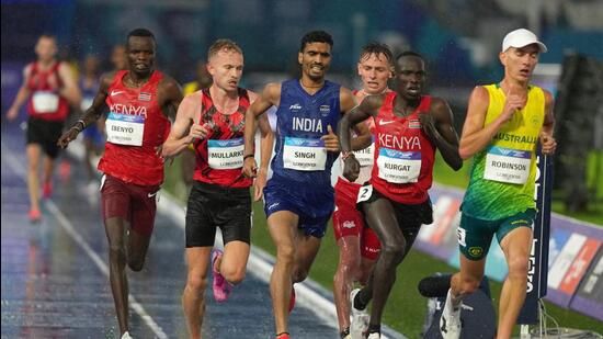 Gulveer Singh of India (blue) competes in the men's 10,000 meters final at the Commonwealth Games in Glasgow, Scotland, Tuesday. (AP Photo/Eranga Jayawardena)