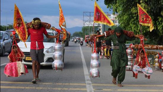 Kanwariyas return home after collecting holy Ganga water on NH-58 in Haridwar on Thursday. (HT photo | Rameshwar Gaur)