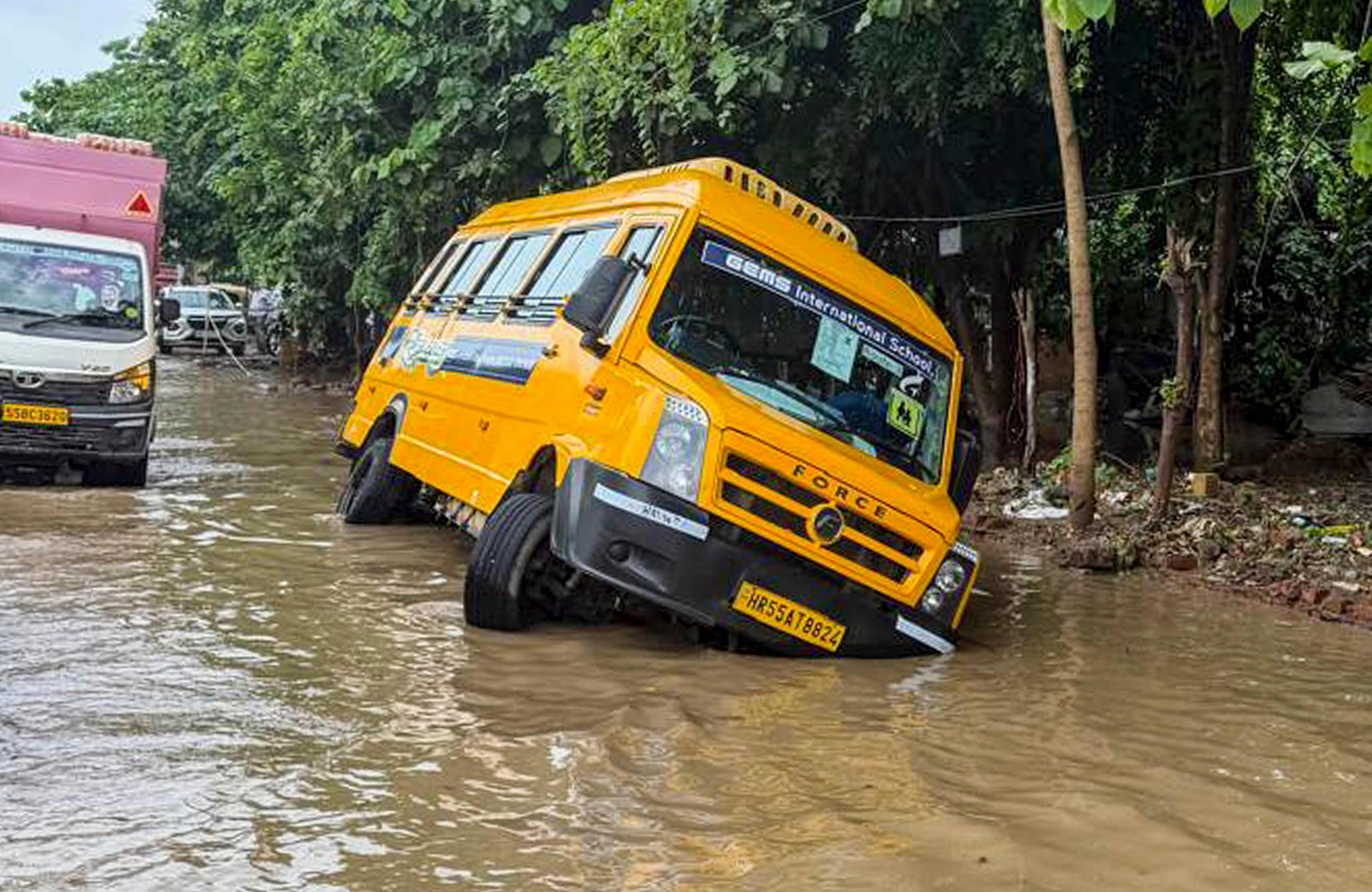 A school bus skid off road on a waterlogged stretch at Palam Vihar on Tuesday. (PTI)