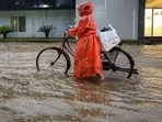 A cyclist wades through a waterlogged road during heavy monsoon rain in Bastar district of Chhattisgarh on Wednesday. (PTI)