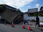 A man helps clean the damaged gate of Jofukuji Buddhist temple in Kumamoto, southwestern Japan, Wednesday, July 29, 2026, the day after an earthquake hit the area. (AP Photo/Hiro Komae)