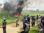 Members of Nepal Police stand next to burnt motorbikes as they wait for a fire engine during a clash between two communities in Siraha, Nepal.