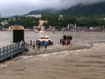 Weather today highlights: People gathered on a portion of the Parmarth Niketan Ghat that remains above water amid rising water levels following rainfall in Rishikesh on Tuesday. 