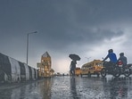 People out in the rain near Akshardham Temple on Wednesday. (RAJ K RAJ /HT PHOTO)
