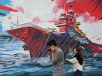 People walk past a mural depicting a U.S. aircraft carrier under missile attack in downtown Tehran, Iran, Sunday, May 17 (AP Photo/Vahid Salemi)