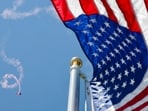 Members of the US Army parachute team 'Golden Knights' perform above a US flag during the 'Salute to America' Independence Day celebration on the National Mall in Washington, DC, on July 4, 2026.