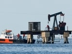 Workers of Venezuelan state oil company, PdVSA, operate a pump jack in Lake Maracaibo.