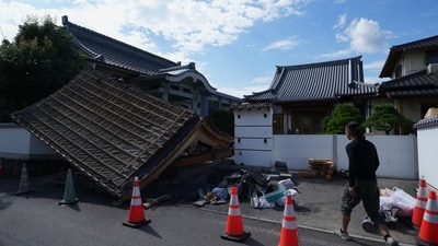 A man helps clean the damaged gate of Jofukuji Buddhist temple in Kumamoto, southwestern Japan, Wednesday, July 29, 2026, the day after an earthquake hit the area. (AP Photo/Hiro Komae) (AP Photo/Hiro Komae) A man helps clean the damaged gate of Jofukuji Buddhist temple in Kumamoto, southwestern Japan, Wednesday, July 29, 2026, the day after an earthquake hit the area. (AP Photo/Hiro Komae) (AP Photo/Hiro Komae)